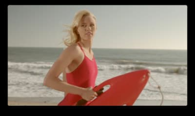 a woman in a red swimsuit holding a red surfboard