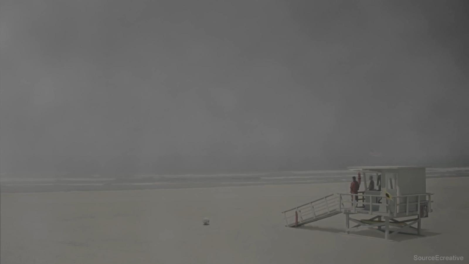 a lifeguard station on a beach with a cloudy sky