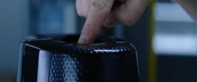 a person pressing a button on a black object
