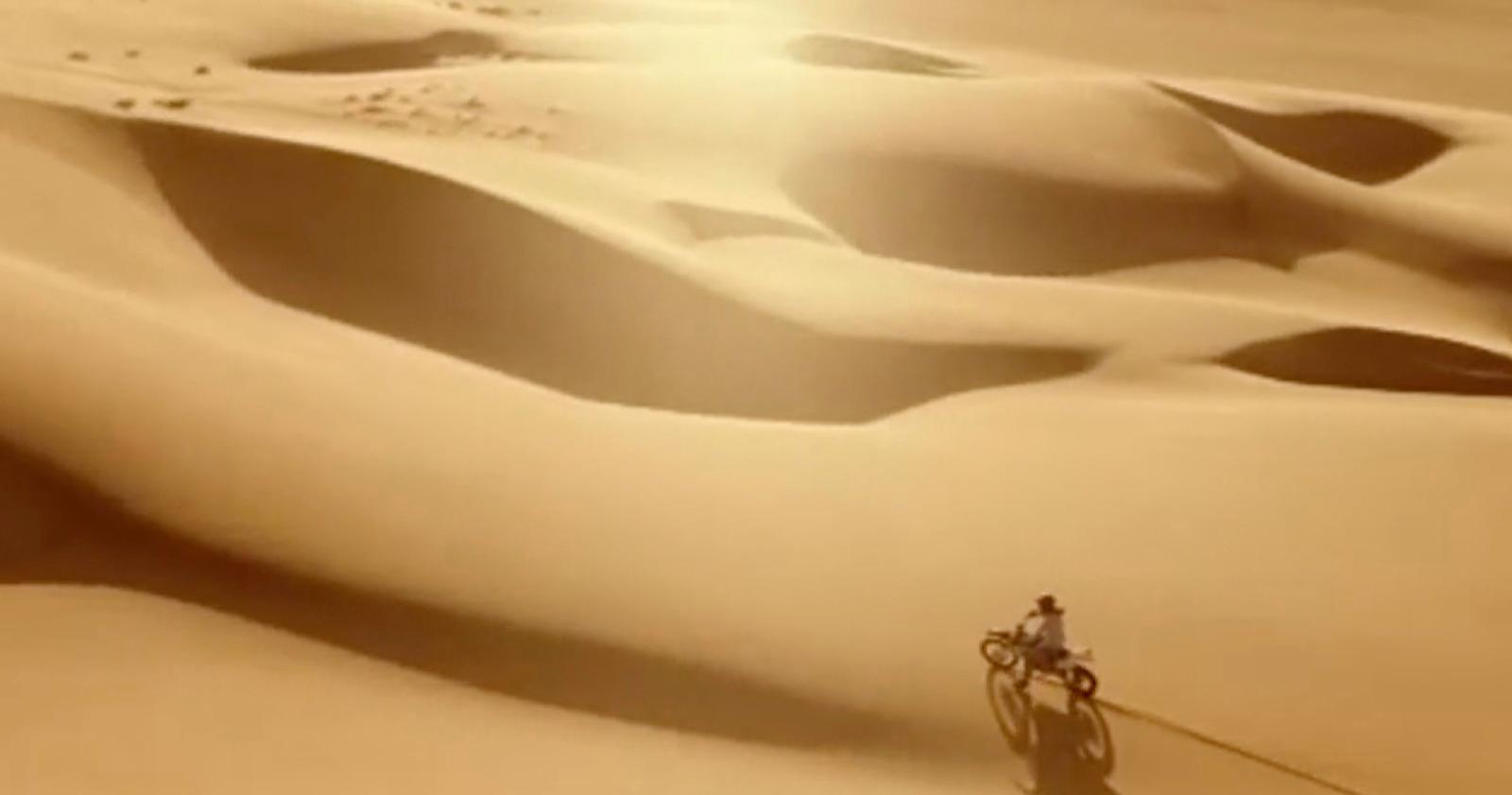 a person riding a bike in the desert