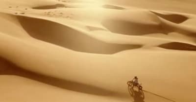 a person riding a bike in the desert