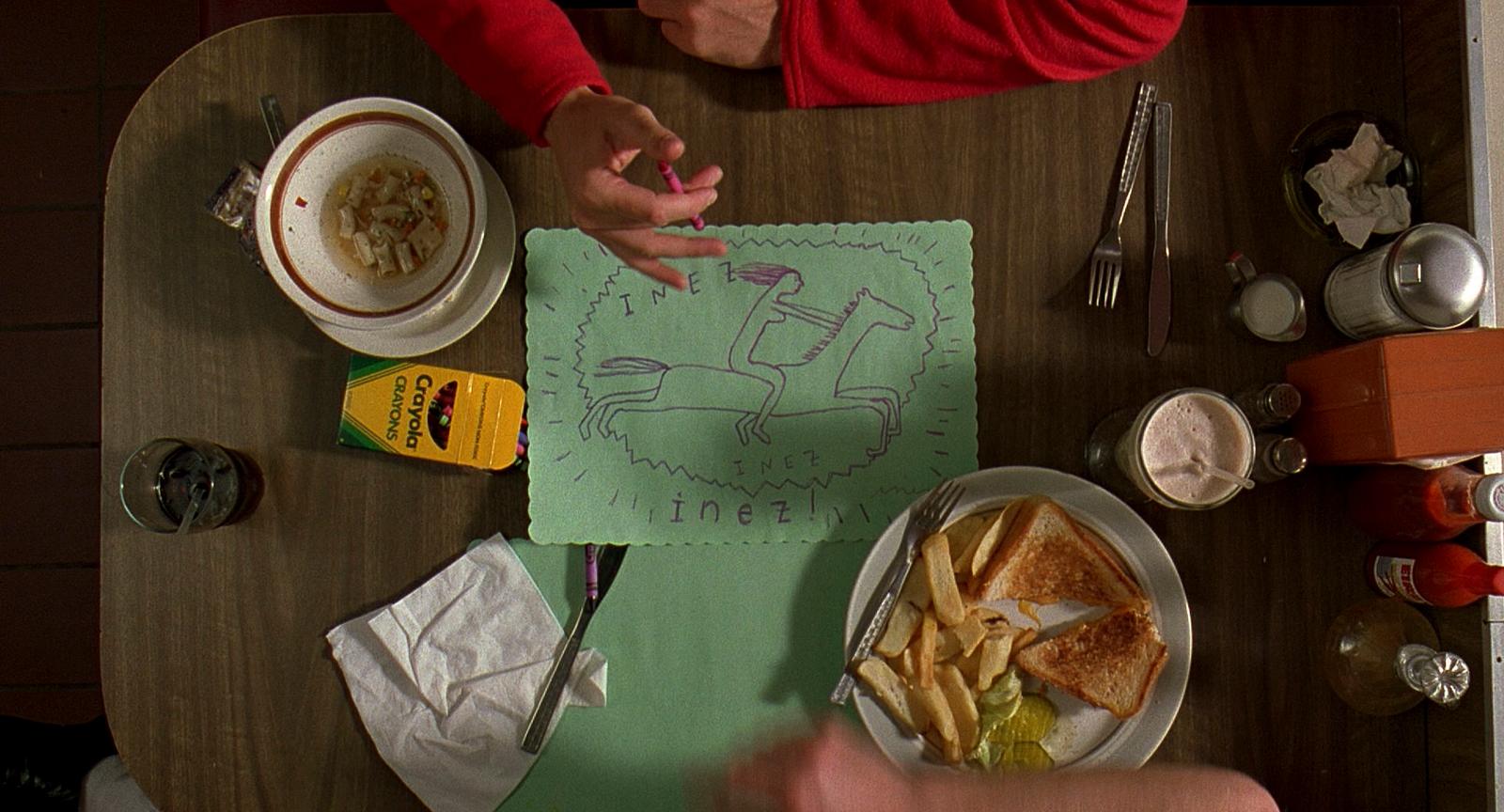two people sitting at a table with a plate of food