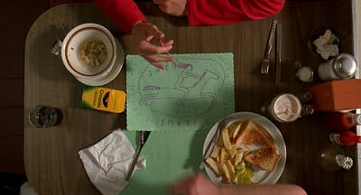 two people sitting at a table with a plate of food