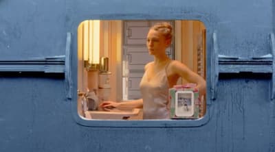 a woman standing in front of a sink in a bathroom
