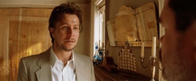 a man in a suit looking at himself in the mirror