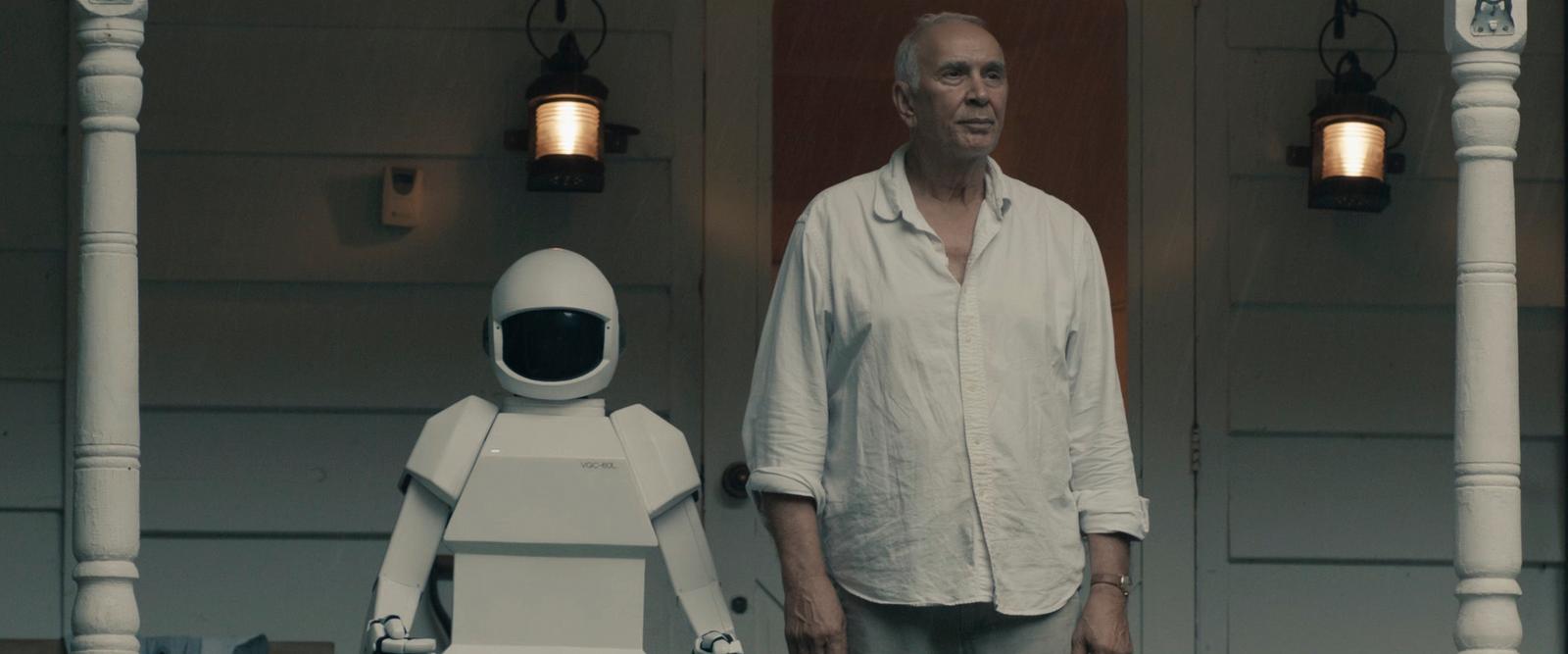 a man standing next to a robot on a porch