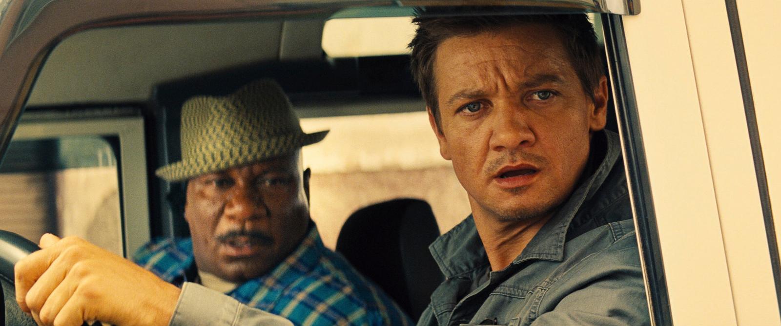 a couple of men sitting in a car next to each other