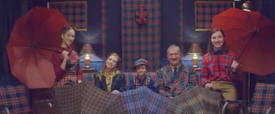 a group of people sitting on a couch with umbrellas