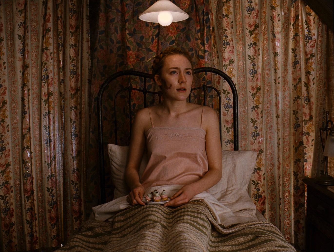 a woman sitting on a bed with a blanket
