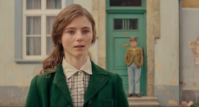 a woman standing in front of a green door