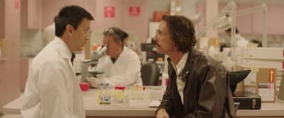two men in lab coats talking to each other
