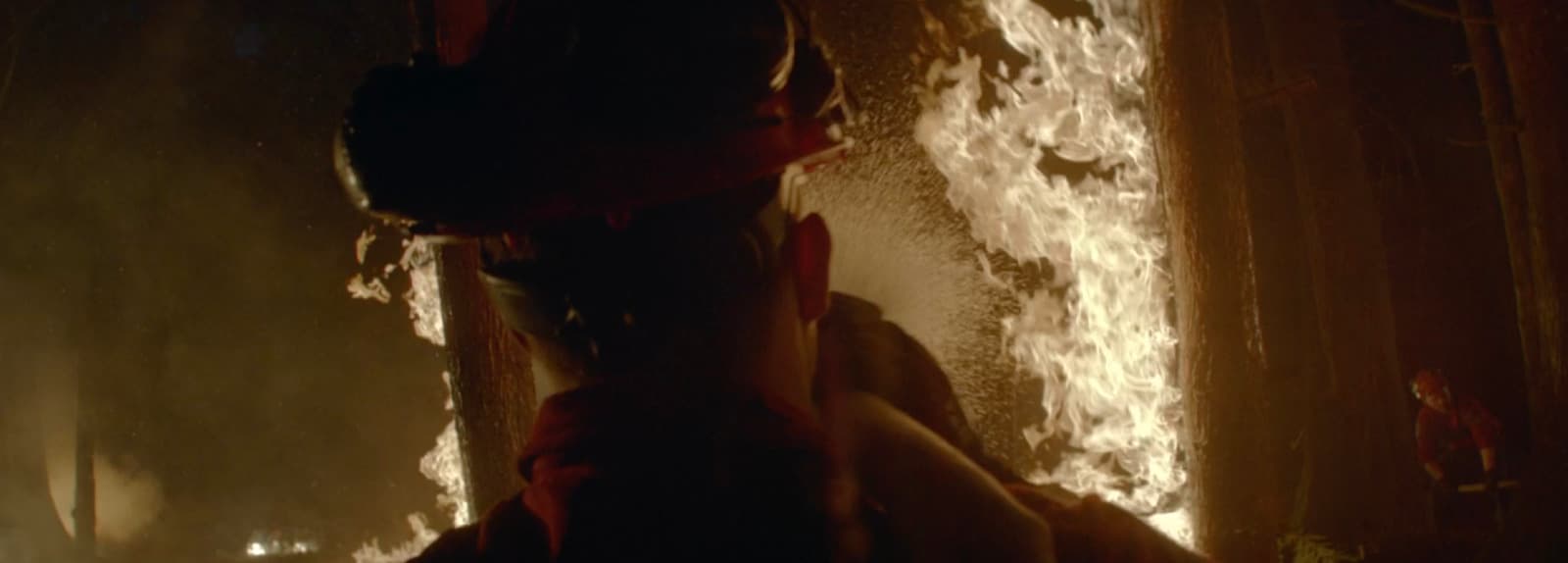 a man is standing in front of a fire