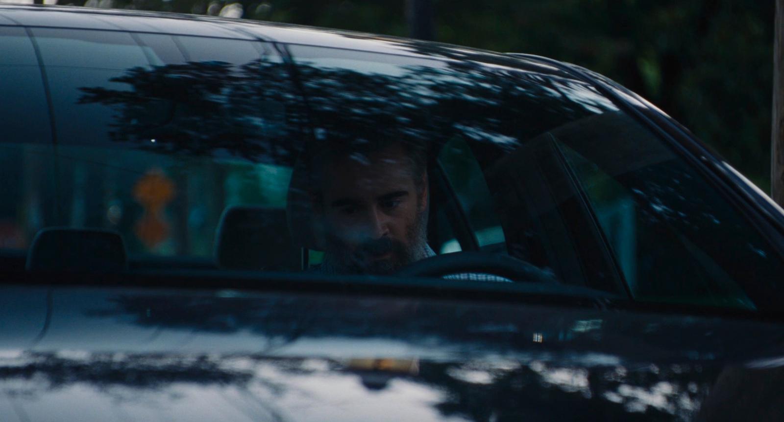a man driving a car in the rain