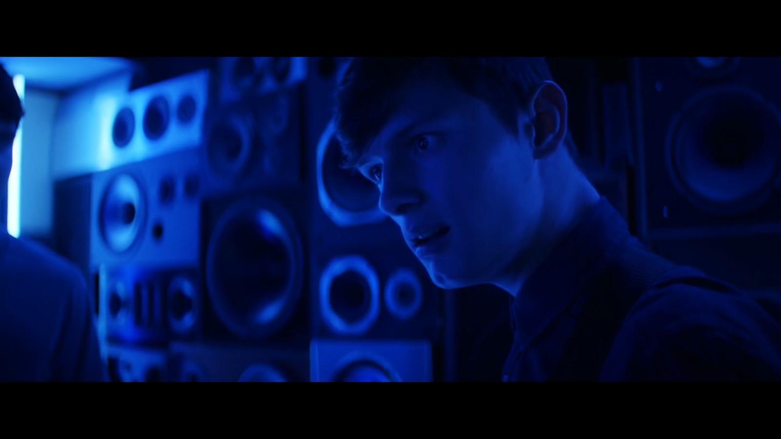a man standing in front of a wall of speakers