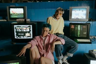 a man and a woman sitting in front of computer monitors