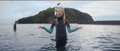 a woman in a wet suit standing in the water