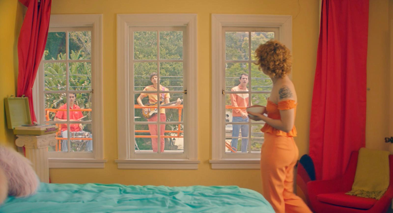 a woman standing in front of a bed in a bedroom