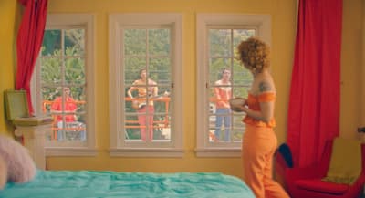 a woman standing in front of a bed in a bedroom