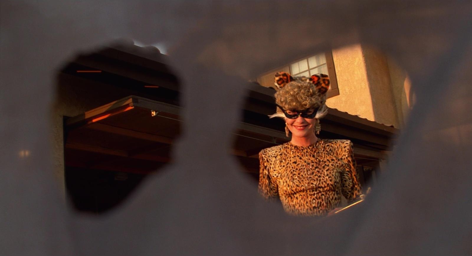 a woman in a leopard print top and sunglasses