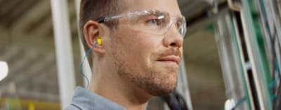 a man wearing safety goggles in a factory