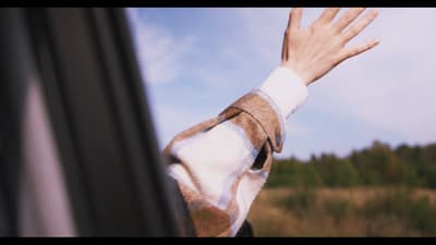 a hand reaching out of a car window