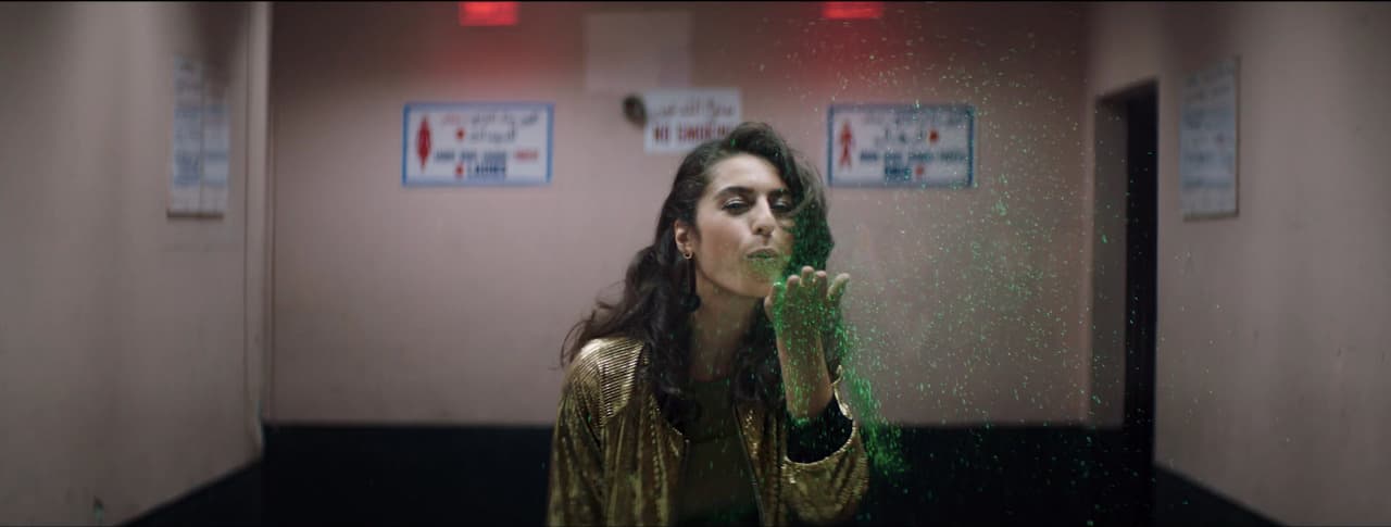 a woman standing in a room with green powder on her face