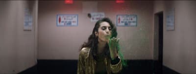 a woman standing in a room with green powder on her face
