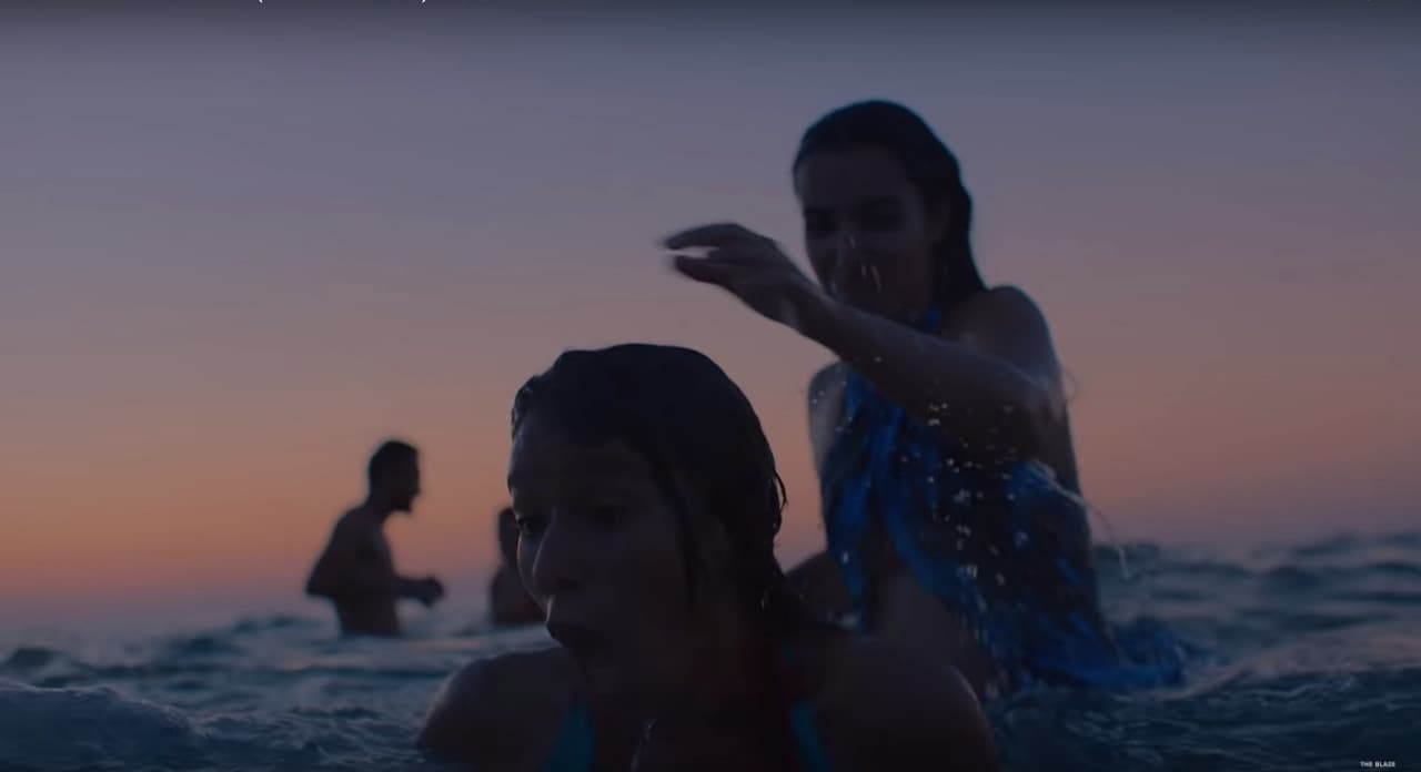 two girls in the ocean at sunset
