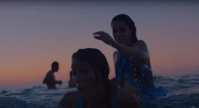 two girls in the ocean at sunset