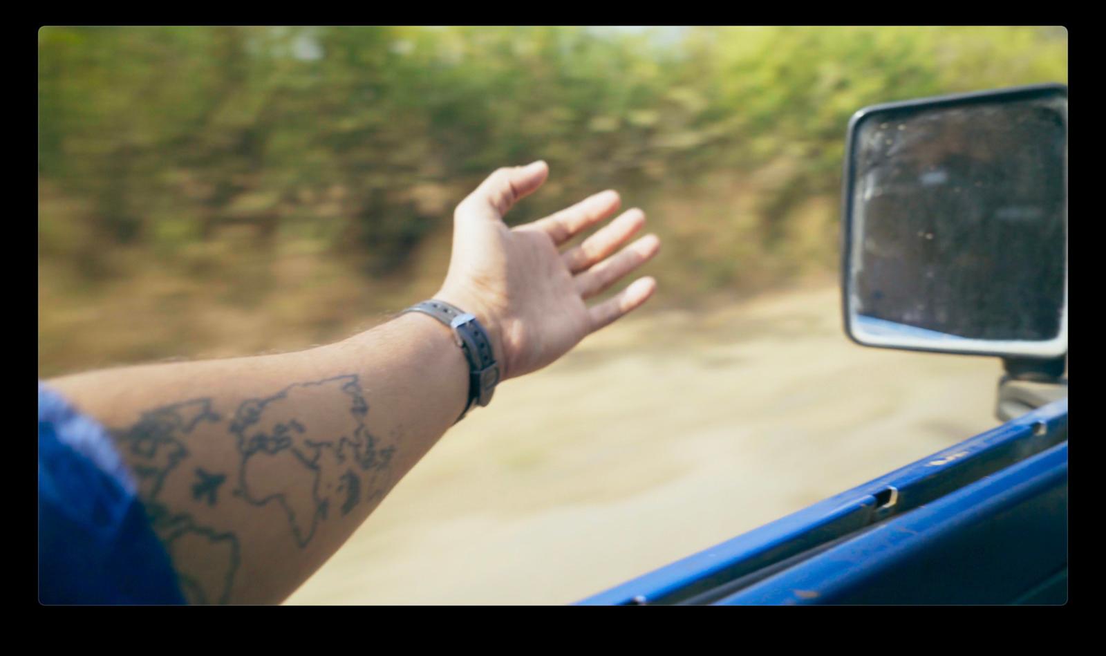 a person's arm and hand out of a car window