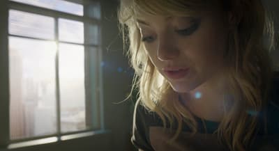 a woman looking at her cell phone in front of a window