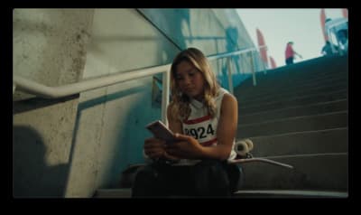 a young girl sitting on the steps using a cell phone