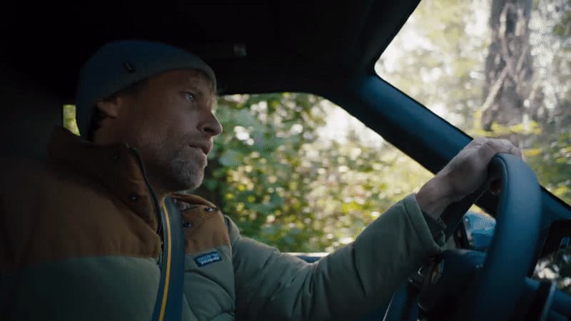 a man driving a car through a forest