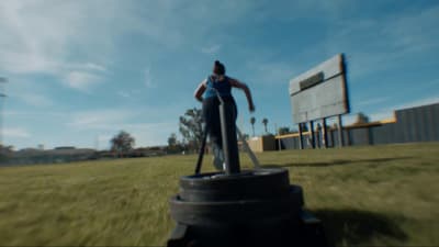 a woman standing on top of a black fire hydrant
