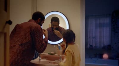 a man and a woman standing in front of a mirror