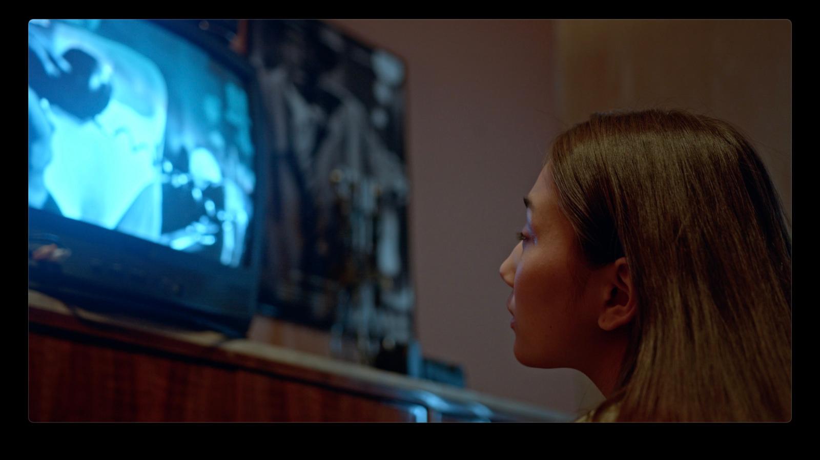 a young girl watching a movie on tv