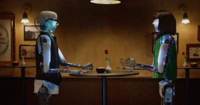 a robot and a woman sitting at a table