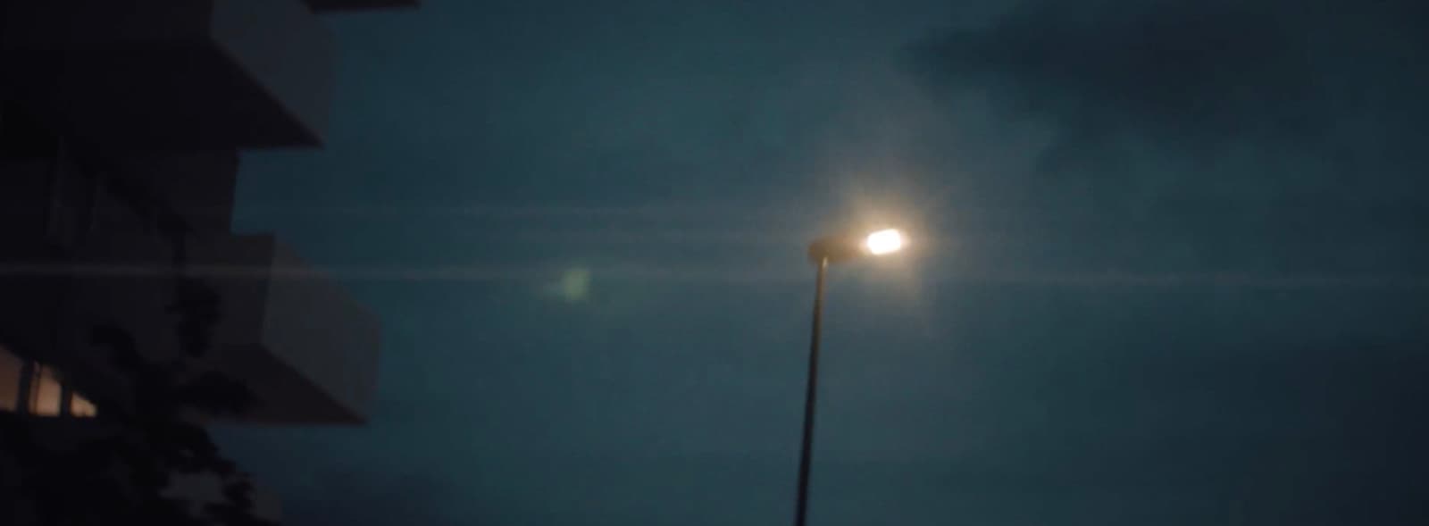 a street light in the dark on a cloudy night