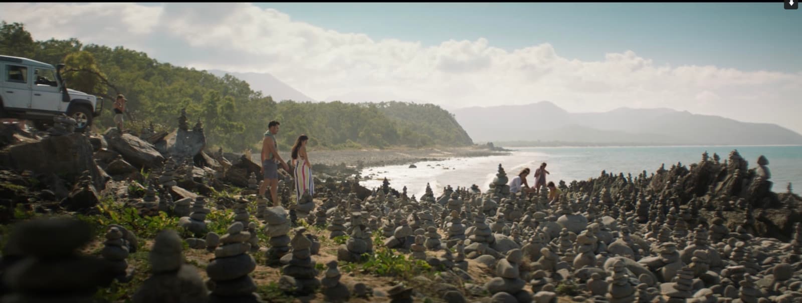 a group of people standing on top of a rocky beach