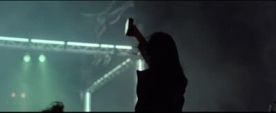 a woman standing in front of a stage holding a cell phone