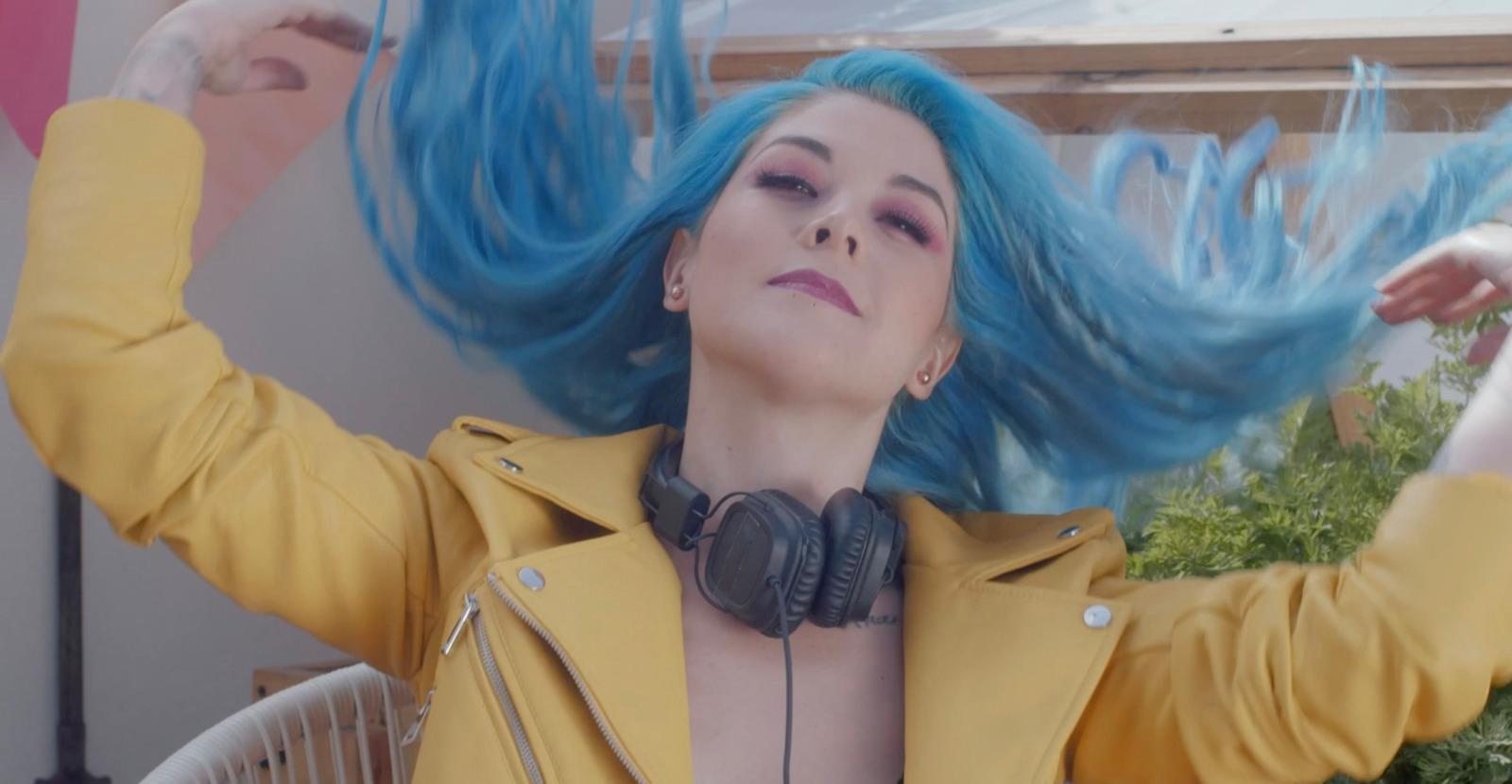 a woman with blue hair wearing headphones