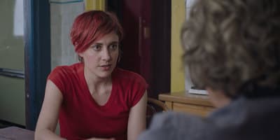 a woman with red hair sitting at a table