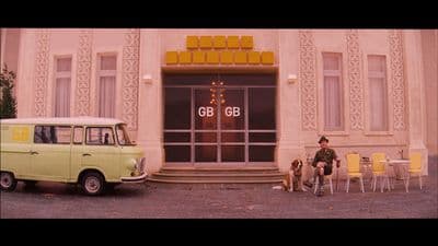 a man sitting on a chair next to a yellow van