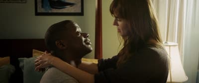 a woman hugging a man in a bedroom