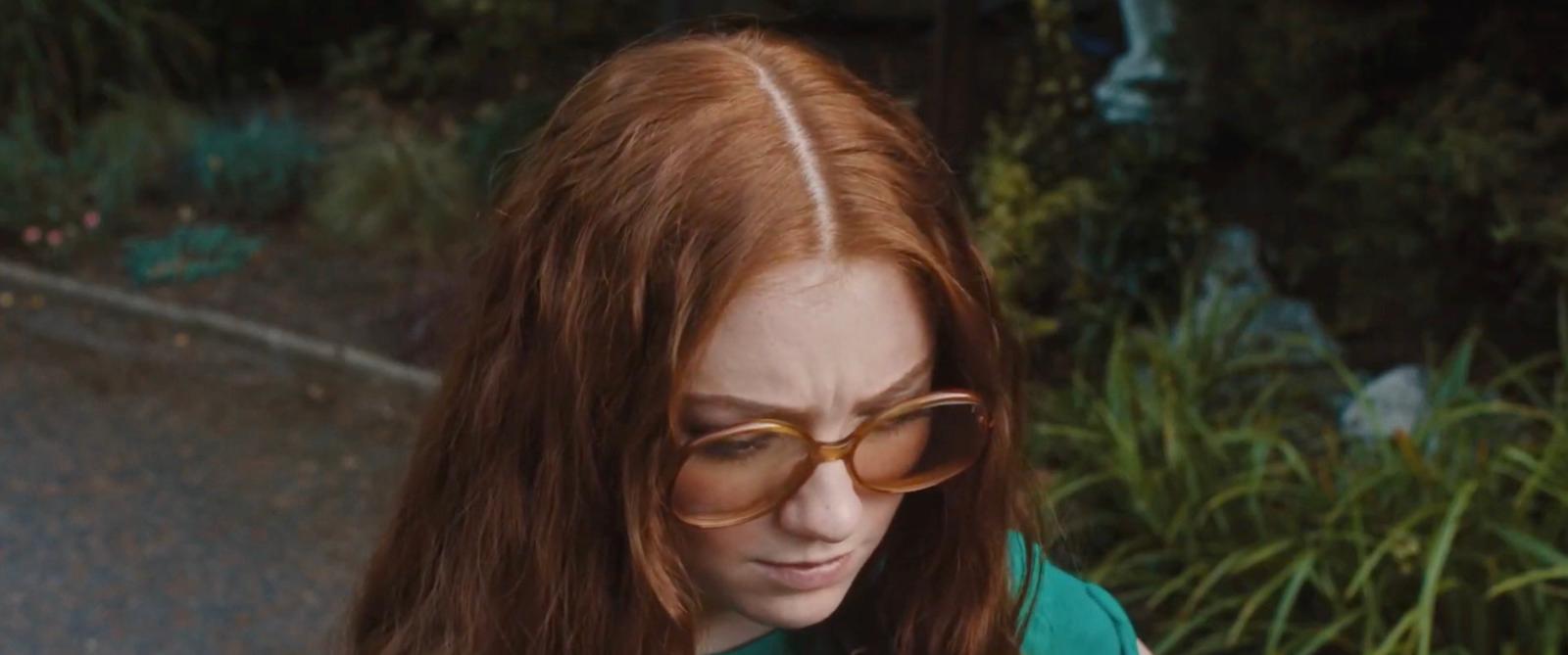 a woman with glasses looking at her cell phone