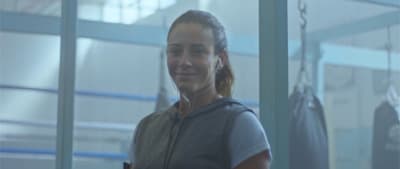 a woman is listening to music in a gym