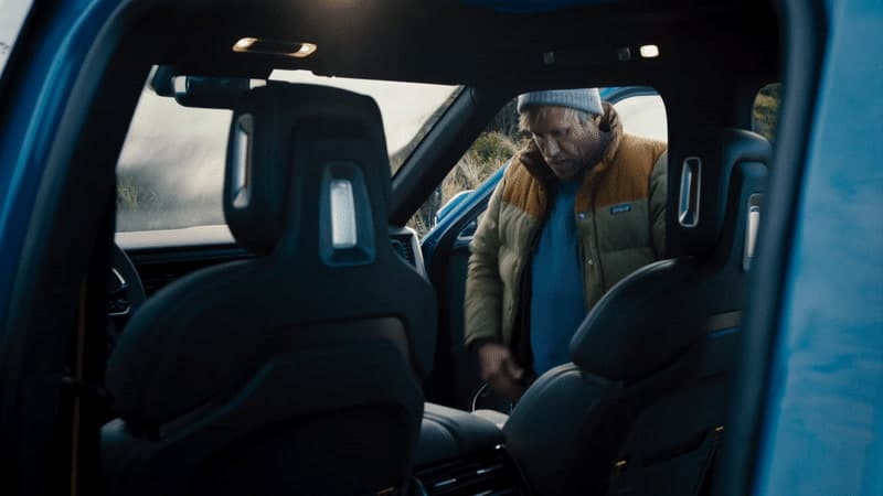 a man sitting in the driver's seat of a blue truck