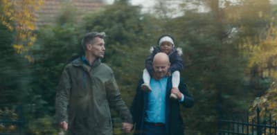a man and a woman walking with a child on their shoulders