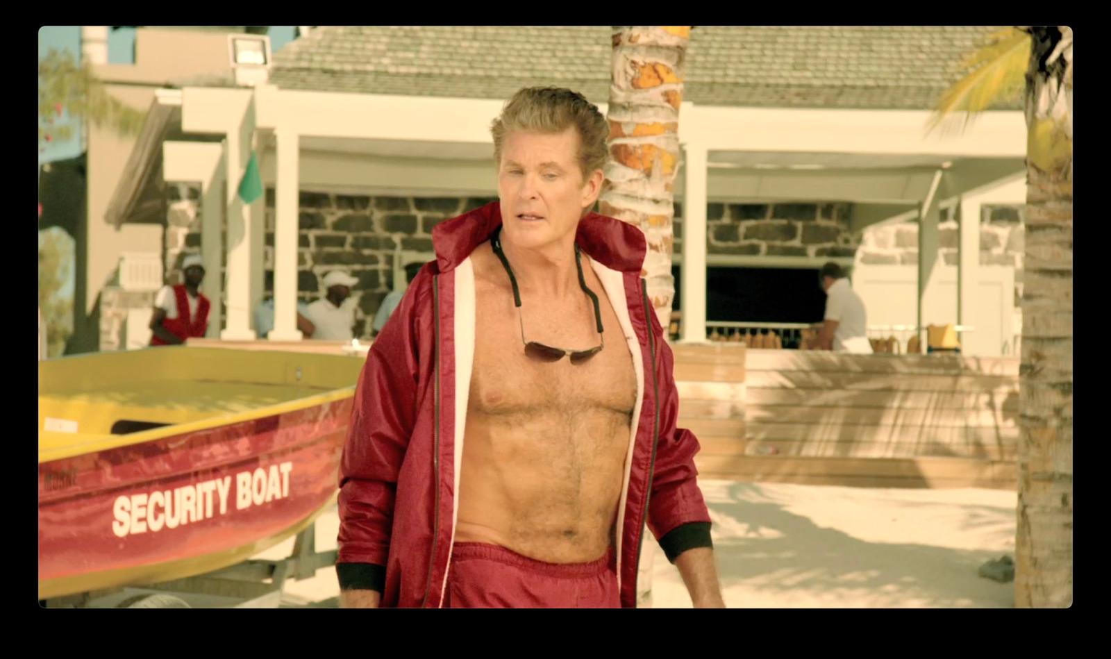 a man with no shirt standing next to a boat