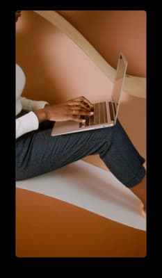 a person sitting on a chair with a laptop